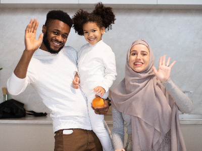 Muslim family happily waving at the camera.